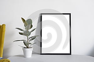 Poster A2 in black frame in nordic stylish modern interior, yellow armchair, ficus, living room. Empty space for design layout