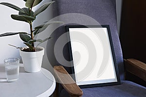 Poster in black frame in nordic stylish modern interior, violet armchair, ficus, living room. Empty space for design layout