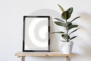 Poster in black frame in white stylish modern interior on a wall above green sofa. Design template mockup