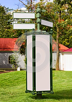 Poster board, and information signs located on the green grass. An empty billboard, a signpost. Photography.