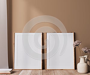 Poster frame mock up in neutral colors interior, two wooden frames with dried flowers vase in beige background