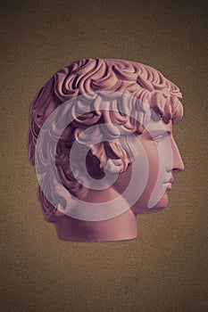 Poster with gypsum copy of ancient famous statue Antinous head on dark textured background. Plaster antique sculpture photo