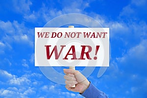 Poster in the hand of a caucasian woman we do not want war. Against the background of blue sky with clouds