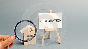 A poster with the inscription Restoration and a broken wooden house. Repair secondary housing. The process of improvement,