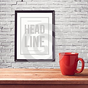 Poster mock up template with red cup on wooden table over brick white wall