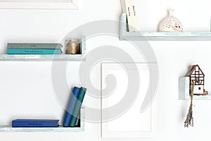 Poster mockup. A blank frame for a drawing on a wall with books and objects