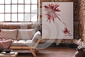 Poster next to window in industrial living room interior with grey wooden settee with blanket