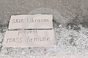 Poster Prevent mass famine. Save Ukraine poster. poster lies on concrete ground