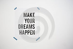 Poster on white wall with the quote make your dreams happen abstract background texture