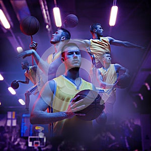 Poster with young sportsmen, basketball players playing basketball isolated on dark background in flashlights