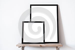 Posters square portrait format in black frame in white stylish modern interior on shelf, living room. Design template mockup