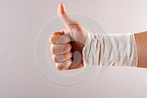Postive gesture of thumbs up by wrapped hand photo