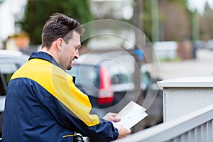 Postman delivering letters to mailbox of recipient