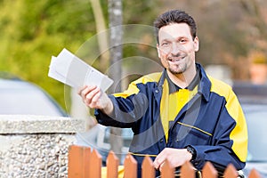 Postman delivering letters to mailbox of recipient photo