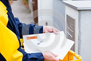 Postman delivering letters to mailbox of recipient