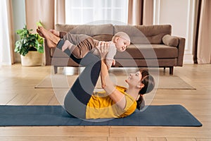 Postpartum recovery. Mommy practicing yoga with her baby photo