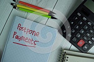 Postpone Payments write on a book isolated on office desk