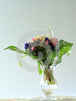 Posy of colourful flowers displayed in a small glass vase.