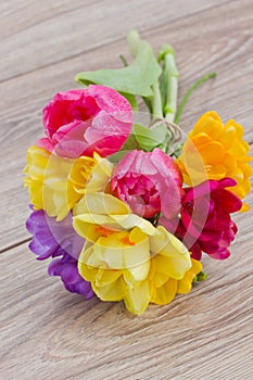 Posy of spring flowers on wooden table