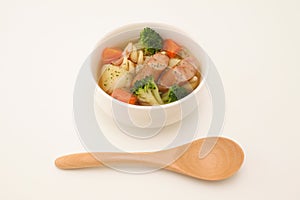 pot-au-feu vegetables sausage soup isolated wood spoon on white background