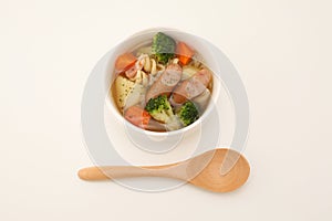 pot-au-feu vegetables sausage soup isolated wood spoon on white background