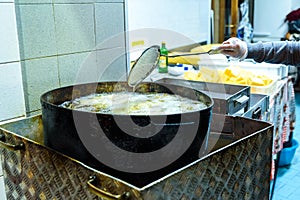 Pot with boiling oil to prepare the typical Polenta Gialla, boiled corn flour, traditional from Italy and countries of South photo