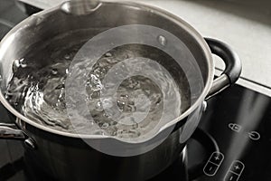 Pot with boiling water on electric stove in kitchen