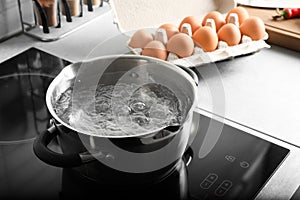 Pot with boiling water on electric stove in kitchen