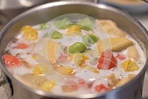 In a pot, colorful dumplings are being boiled. Preparing lunch or dinner