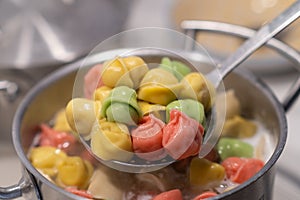 In a pot, colorful dumplings are being boiled. Preparing lunch or dinner