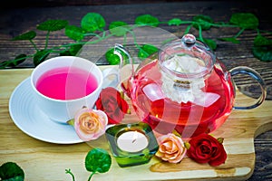 pot and cup of Rose tea on wood background