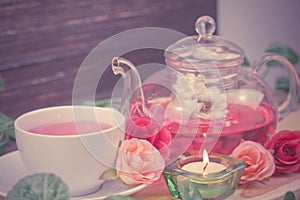 pot and cup of Rose tea on wood background