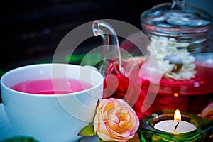 pot and cup of Rose tea on wood background