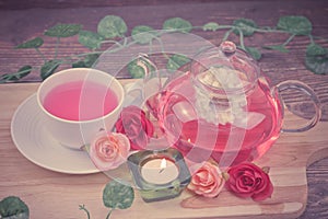 pot and cup of Rose tea on wood background