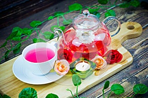 pot and cup of Rose tea on wood background