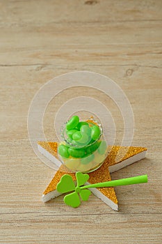 A pot filled with yellow and green jellybeans on top of a golden star with a shamrock