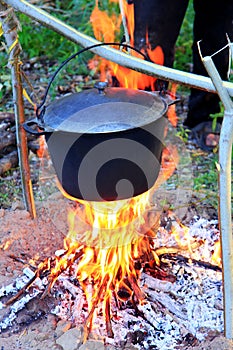 Pot of fish soup being prepared on the fire, a warm evening