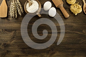 Pot of flour, wheat ears, pasta, kitchen utensils on wooden background. homemade, menu, recipe, mock up