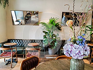 Pot with fresh flowers on the tables in vintage cafe, luxuary interior. Cafe table, empty , no people