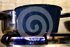 Pot on the gas stove with blue flamme