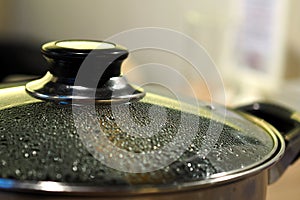 Pot with glass lid closeup to see water steam drops