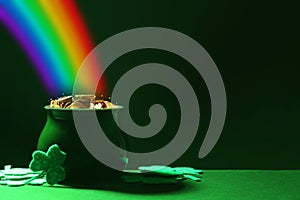 Pot with gold coins and clover leaves on table, space for text. St. Patrick`s Day celebration photo