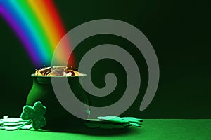 Pot with gold coins and clover leaves on table, space for text. St. Patrick`s Day celebration