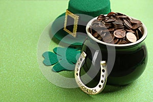 Pot of gold coins, horseshoe, hat and clover on background, space for text. St. Patrick`s Day celebration