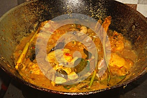 A pot of half-cooked chicken curry.