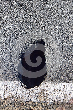 A pot hole in the asphalt road in need of maintenance