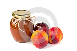 Pot of jam on white background with ripe appetizing peaches