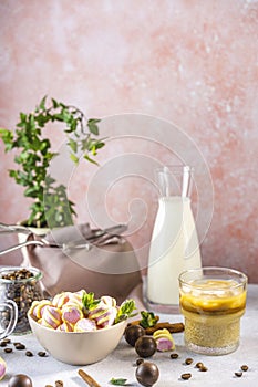 Pot of marshmallow and glass of brew cold coffee and ice. Cold summer drink on a light gray table