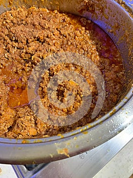 pot with meat ragu, long-cooked meat sauce, Italian ragu made of beef and pork and tomatoes