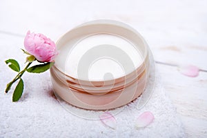 Pot of moisturizing face cream and beautiful flower on a white wooden background. natural organic cosmetic facial.